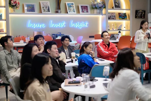 ผู้เข้าร่วมนั่งฟังการบรรยายหน้าผนังไฟ Insure Invest Insight
