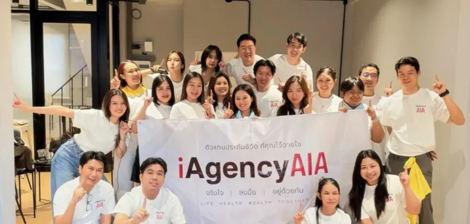ทีมที่ปรึกษา iAgencyAIA ถือป้ายทีมถ่ายรูปหมู่ในงานของทีม